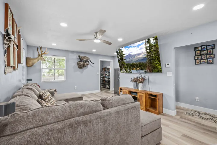 Living area featuring wood-finish flooring, recessed lighting, and a ceiling fan
