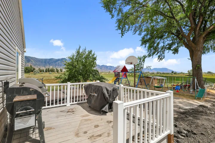 Spacious outdoor deck with white railing, featuring open land views and distant mountains