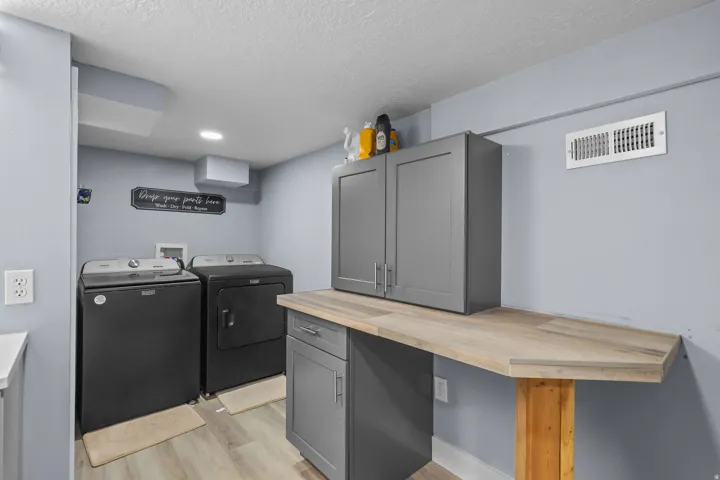 Dedicated laundry area featuring light wood-finish flooring