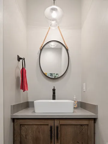 Modern vanity featuring a vessel sink, dark wood-finish cabinetry, and a stone countertop