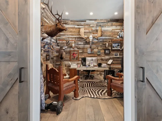 Office space featuring a wood-finish accent wall, recessed lighting, and wood-finish flooring