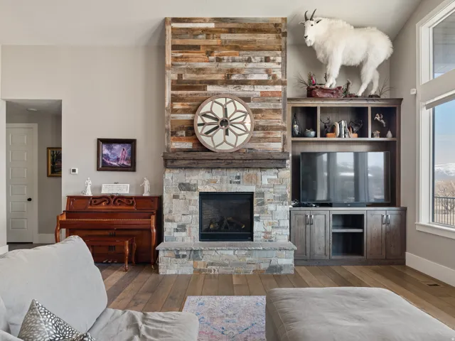 Central fireplace featuring a stone surround and wood-finish mantle