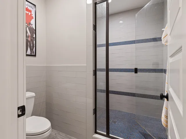 Walk-in shower with dark-framed glass enclosure