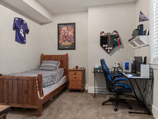 Carpeted room featuring light gray walls, a window with horizontal blinds, and a built-in ceiling beam