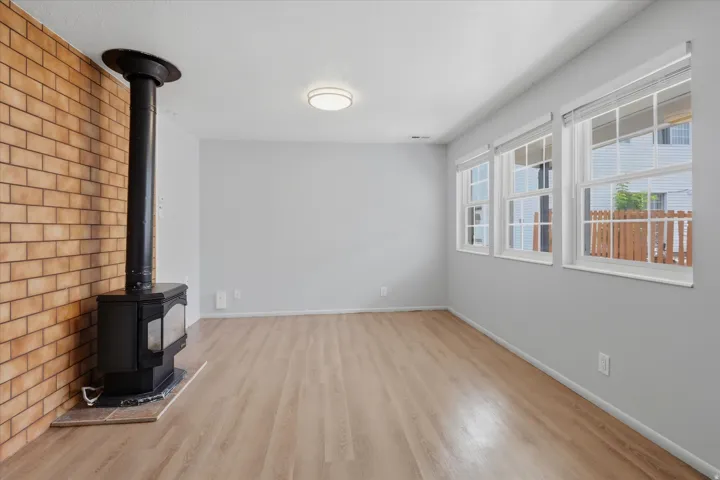 Living room with functioning gas stove and 3 bright windows