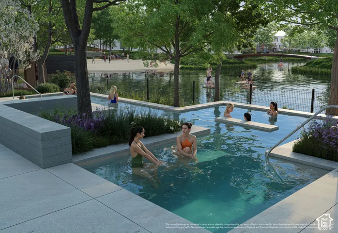 Multi-level pool area with integrated planters, surrounding hardscaping, and a perimeter fence, overlooking a body of water with a sandy shore