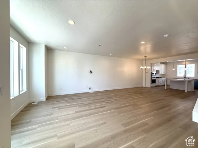 Open-concept living area featuring wood-finish flooring, recessed lighting, and large windows