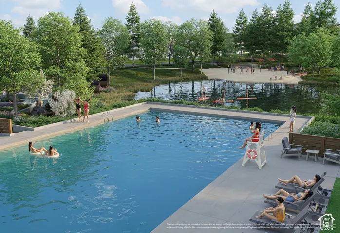 Expansive outdoor swimming pool with surrounding hardscaping, adjacent natural pond, sandy beach area, and ample green space