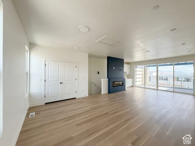 Wood-finish flooring, recessed lighting, built-in fireplace, sliding glass doors, and mountain scenery