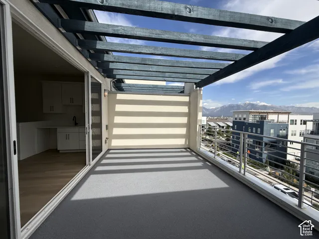 Expansive deck featuring a pergola, metal railing, and a durable grey surface