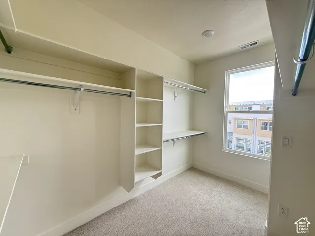 Built-in storage solutions with shelving, hanging rods, and a window for natural light