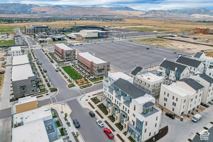 Mixed-use development featuring multi-story residential buildings, commercial structures, structured parking, and integrated green spaces