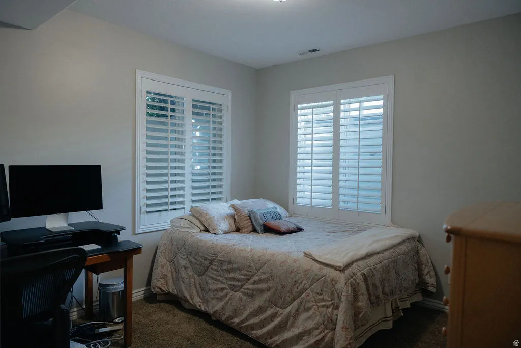 Neutral wall paint tones complement plantation shutters and carpeted flooring