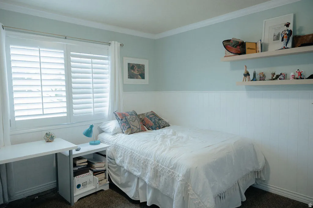 The white louvered shutters, crown molding, wainscoting make this bedroom appealing and inviting.