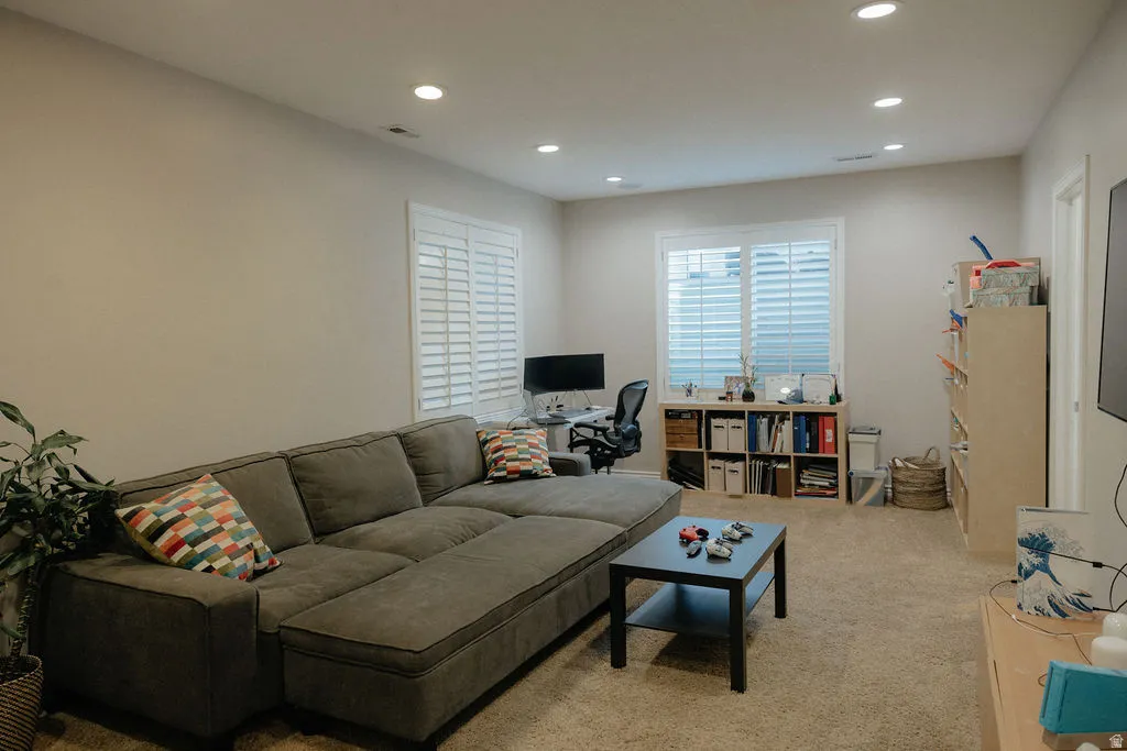 Recessed lighting illuminates neutral-toned walls and carpeted flooring