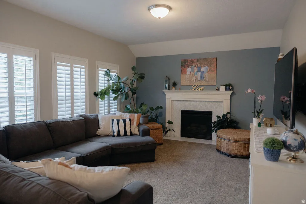 Living room featuring a fireplace with a white mantel, hearth with tile surround, and a black firebox
