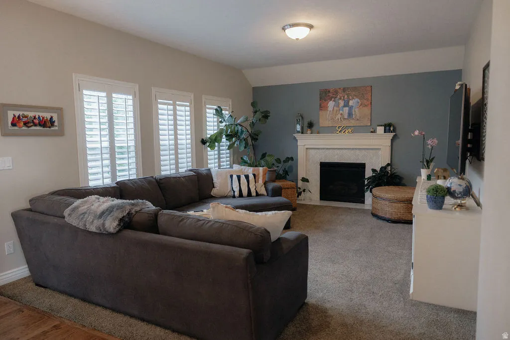 Living area featuring a fireplace with a white mantel and tile surround