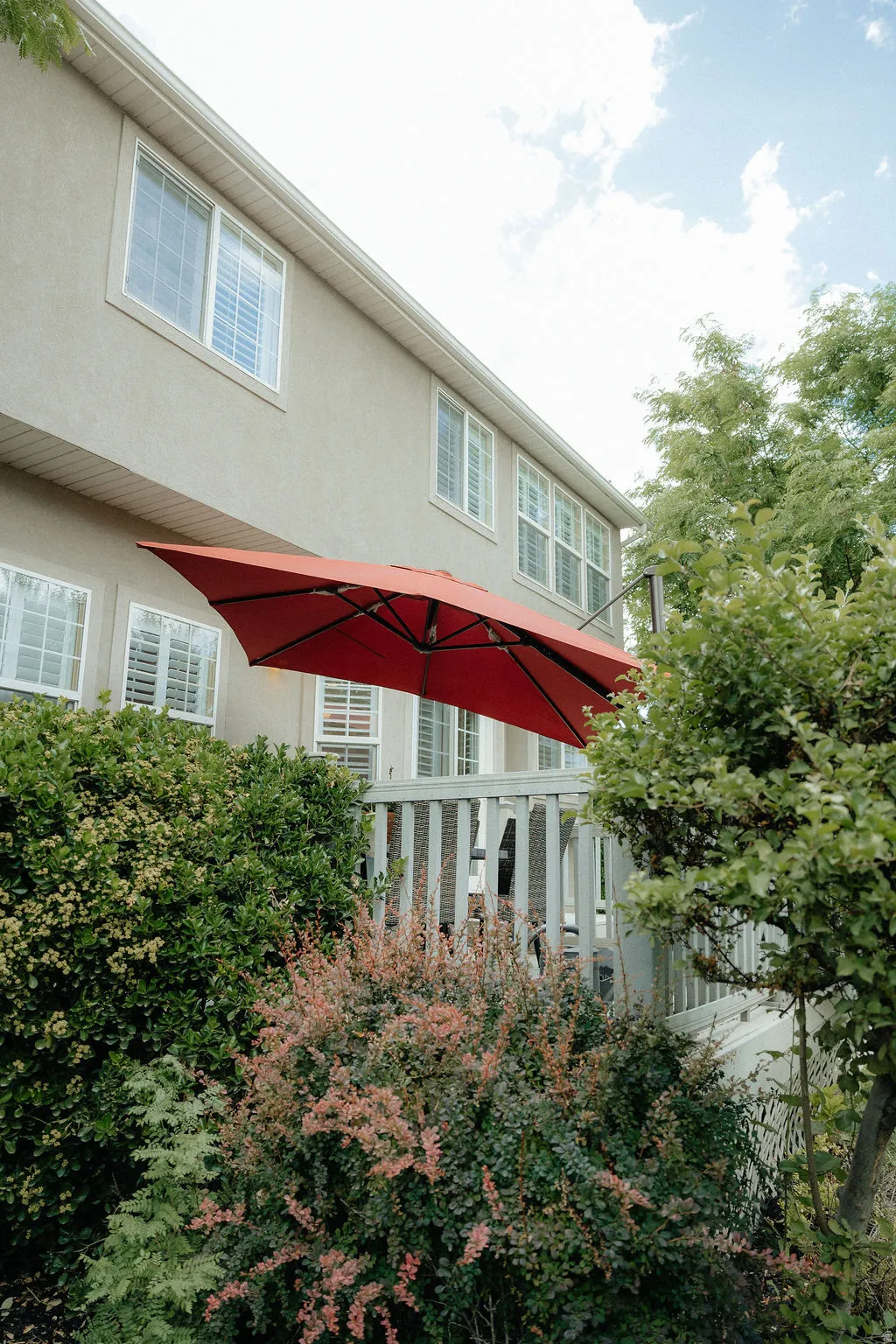 Exterior stucco siding with multiple windows featuring white blinds
