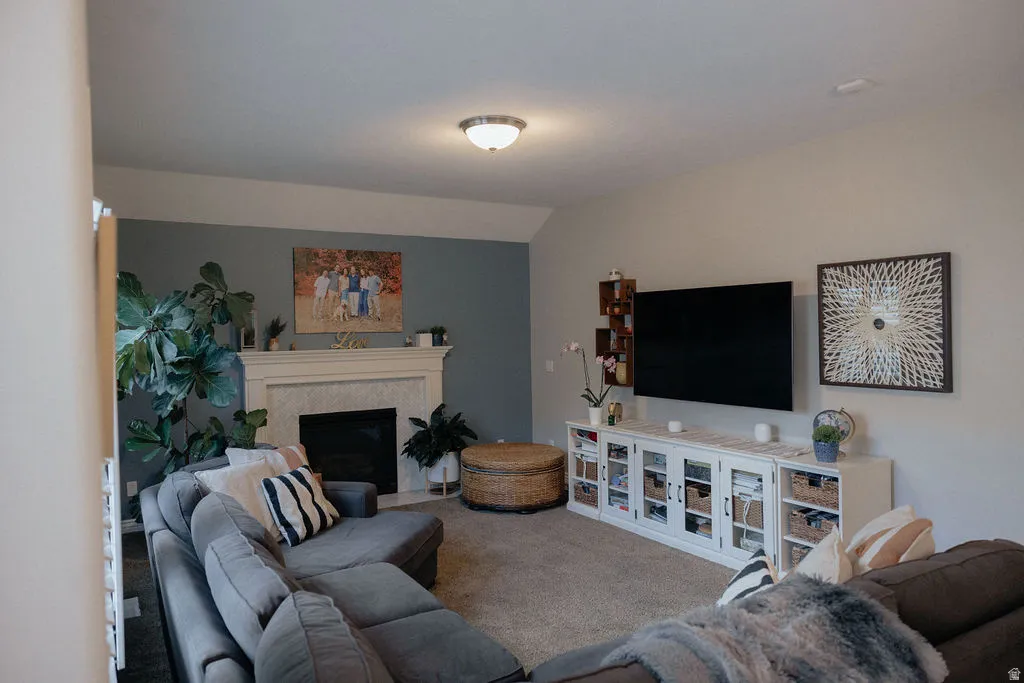 Living area featuring a textured fireplace surround, a mantel, and a contrasting accent wall