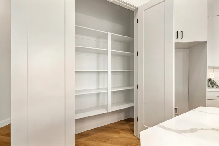Floor-to-ceiling pantry with multiple white shelving tiers