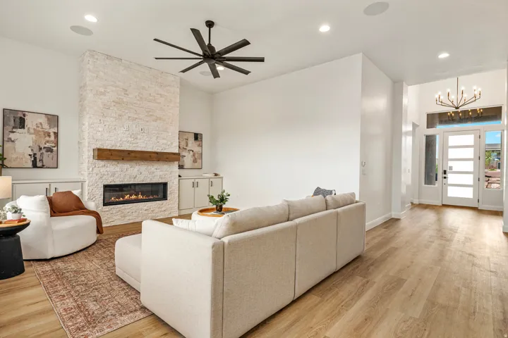 Living area featuring a floor-to-ceiling stone-clad fireplace with a wood mantel and linear firebox