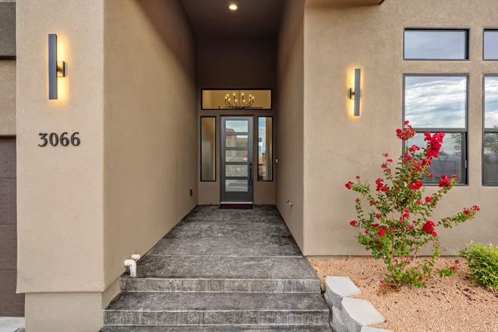 Modern stucco exterior with a recessed entryway, featuring an opaque glass front door and surrounding sidelights