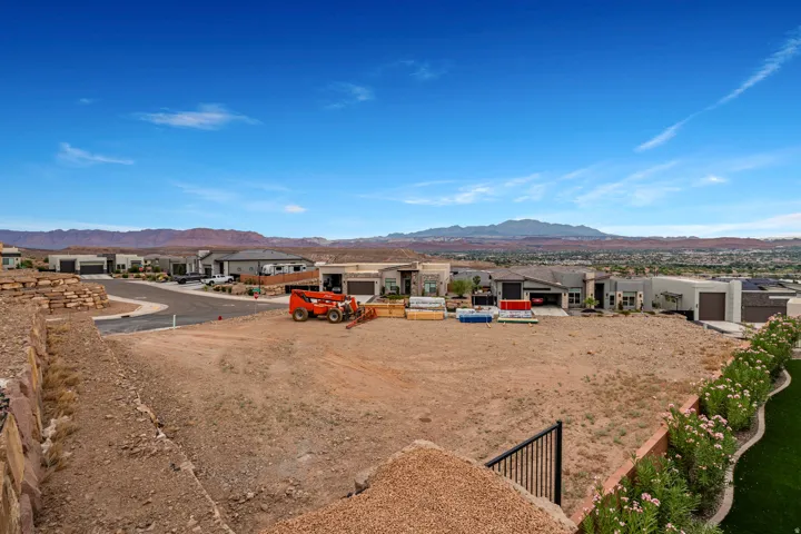 Expansive building lot featuring distant mountain scenery and surrounding residential properties