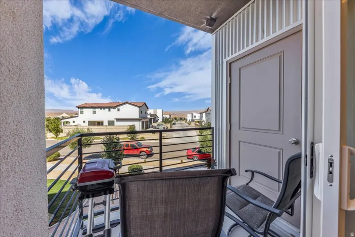 Private balcony featuring a metal railing, corrugated metal siding, and a neutral-toned door