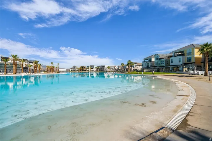 Expansive artificial lagoon with a shallow entry point, bordered by a concrete pathway