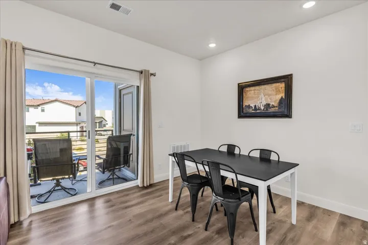 Interior space with wood-finish flooring, white walls, and recessed lighting