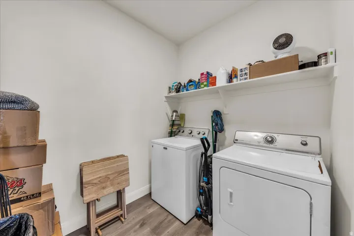 Dedicated laundry space featuring wood-finish flooring and white walls