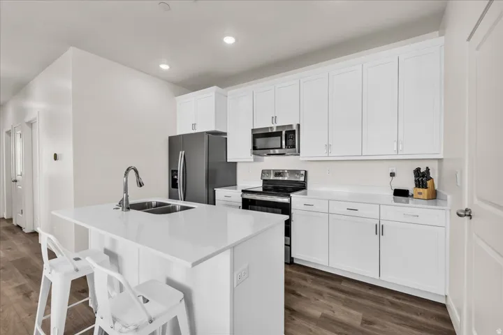 Modern kitchen featuring a central island with an integrated double basin sink and chrome faucet