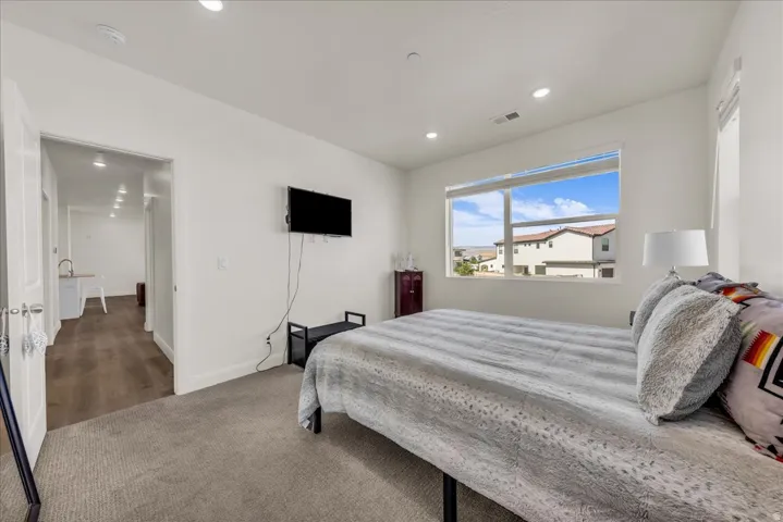 Light-filled room featuring a large window, recessed lighting, and carpet flooring