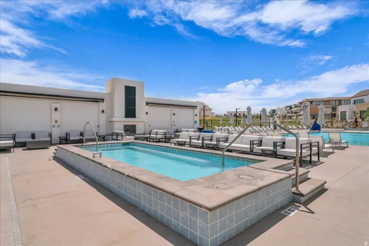 Outdoor aquatic area featuring a rectangular pool with integrated steps and a light blue tiled surround