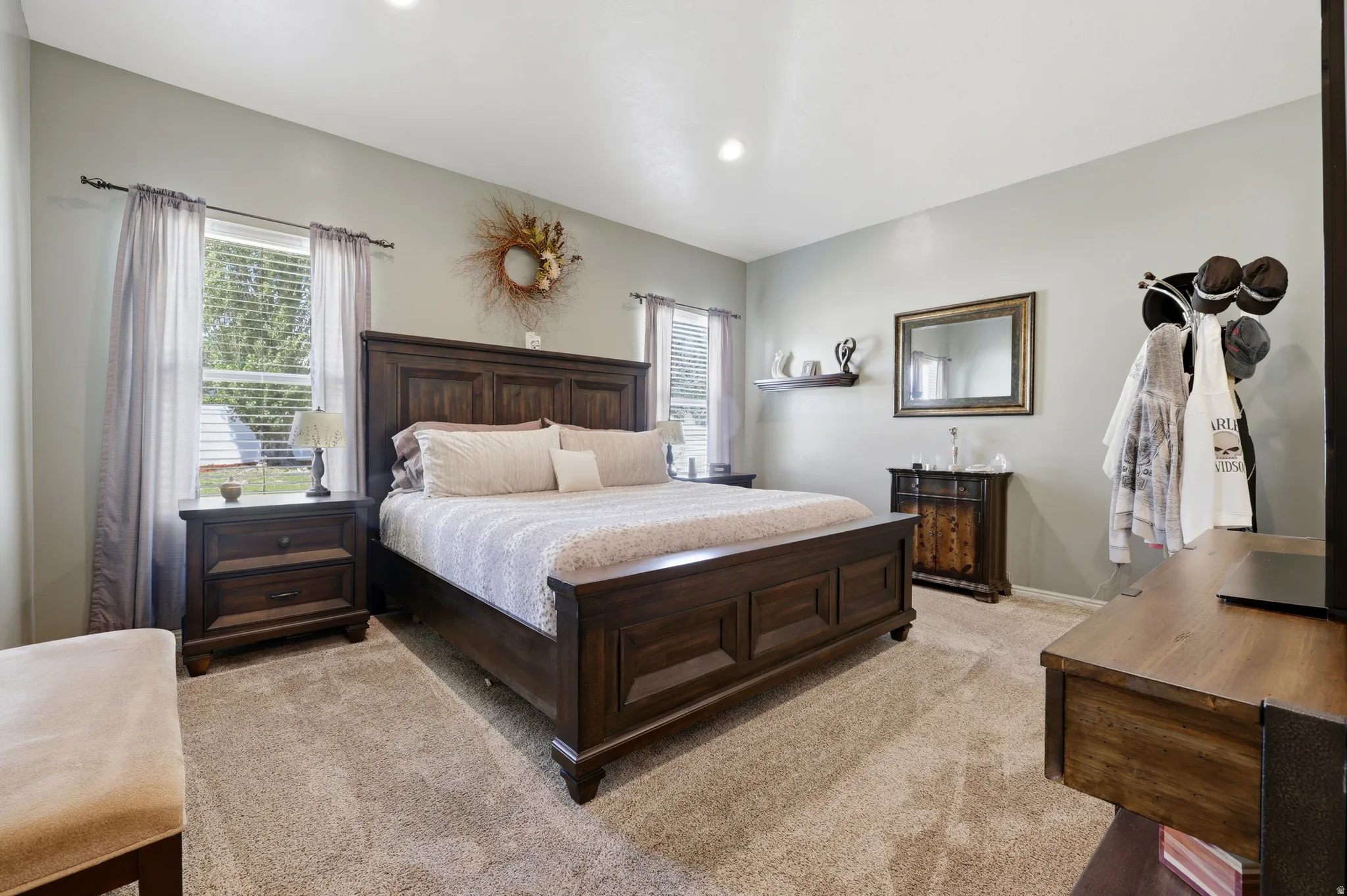 Spacious room featuring neutral carpeting, recessed lighting, and two windows providing natural illumination
