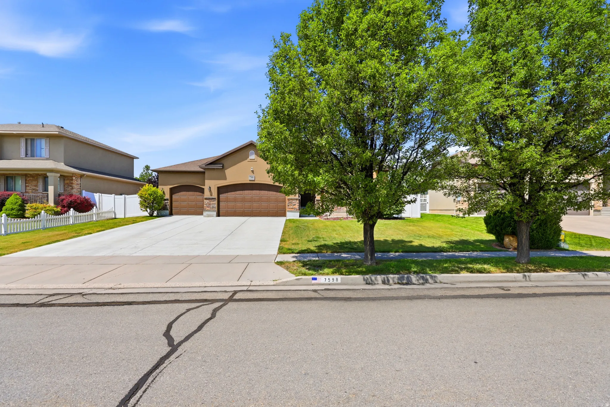 Exterior featuring a neutral-toned facade and an attached two-car garage with wood-finish doors