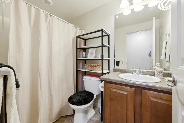 Bathroom featuring a single vanity with an integrated sink, wood-finish cabinetry, and a neutral countertop