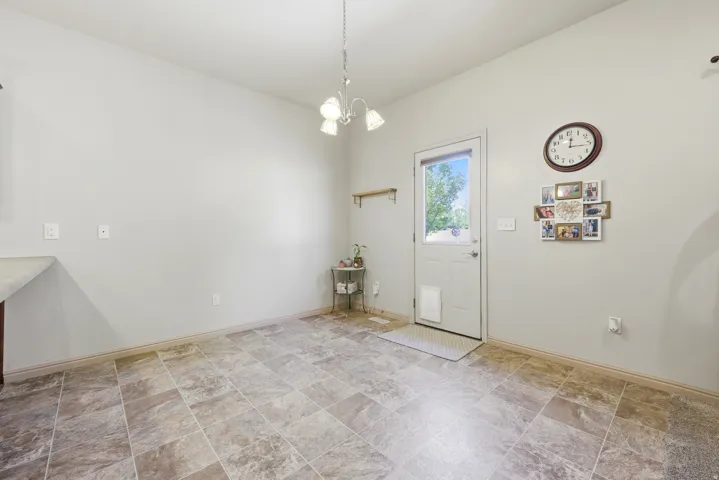 Neutral tone interior space featuring a glass-paneled exterior door, patterned tile flooring, and a ceiling-mounted light fixture