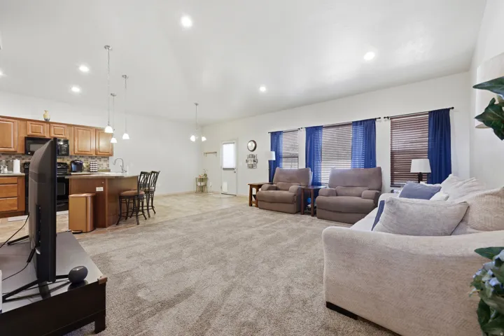 Open-concept living area featuring a kitchen with wood cabinetry, a breakfast bar, and pendant lighting