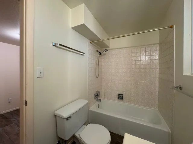 Bathroom featuring a white bathtub, patterned ceramic wall tiles, and a chrome shower fixture