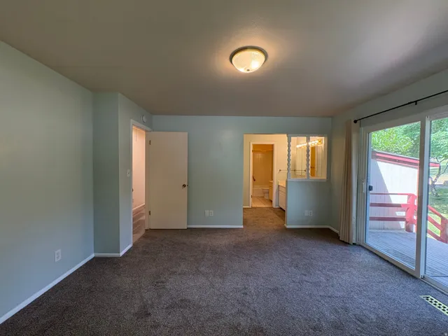 Spacious room featuring neutral carpeting and light-colored walls
