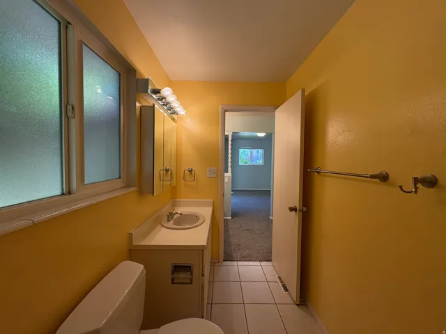 Bathroom with a single vanity, integrated sink, and white countertop