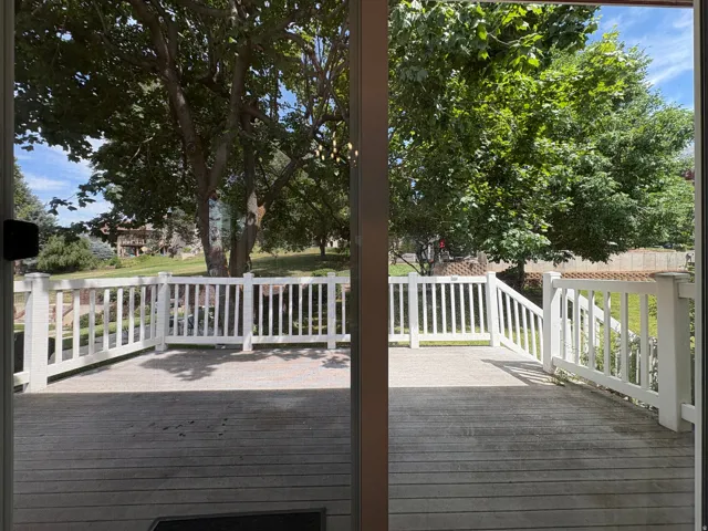 Expansive outdoor deck featuring wood-finish flooring and white perimeter railing