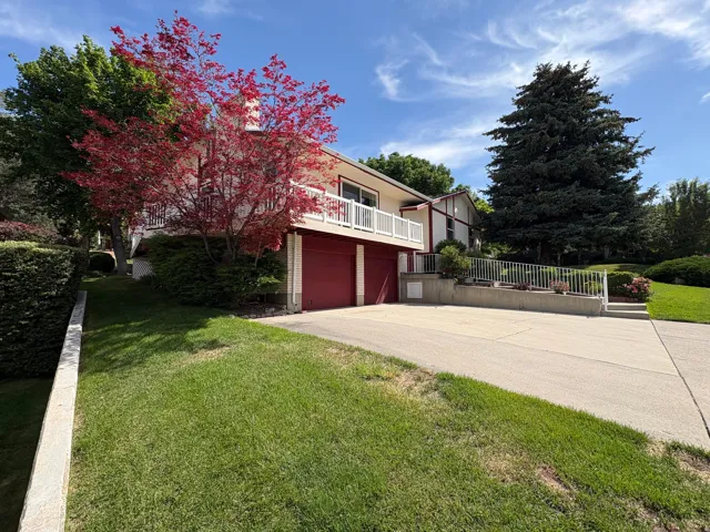 Multi-level residence featuring a two-car garage with red doors and a white exterior facade
