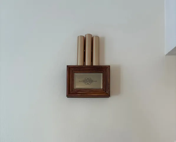 Decorative chime unit with a wood-finish frame and three vertical brass-tone tubes