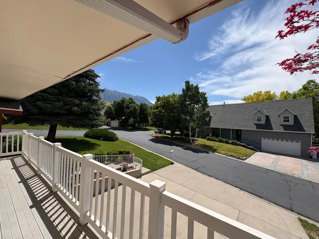 Elevated deck with white railing, featuring a composite wood-finish surface