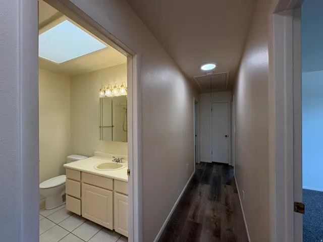 Hallway featuring wood-finish flooring, recessed lighting, and access to additional rooms