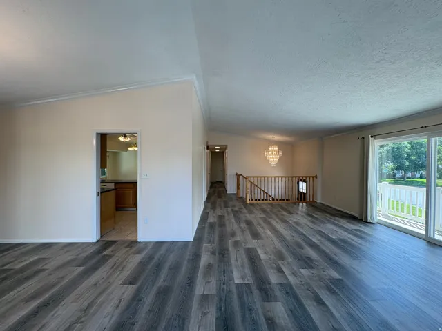 Spacious living area featuring wood-finish flooring and a vaulted ceiling