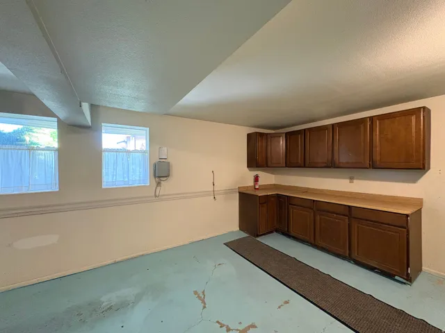 Utility room featuring multiple windows, extensive built-in cabinetry, and a spacious countertop
