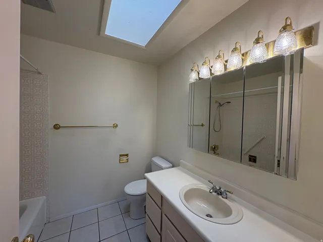 Bathroom featuring a white vanity with an integrated sink, polished chrome faucet, and a large mirrored medicine cabinet